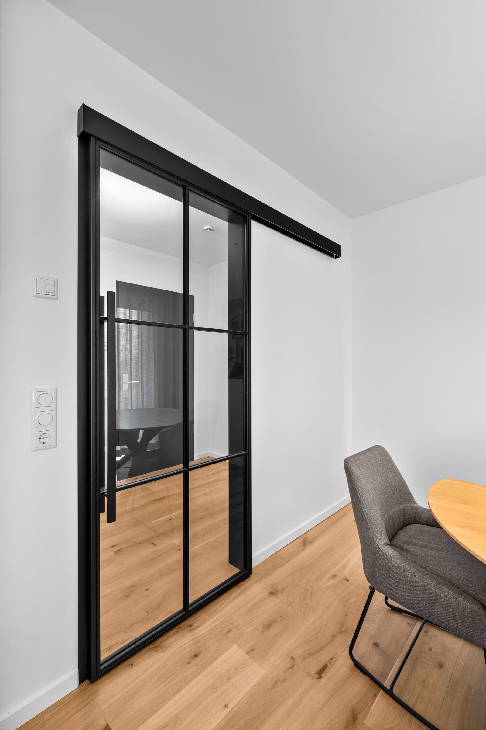 Geöffnete Stahl-Glas-Schiebetür mit Blick in den Besprechungsraum