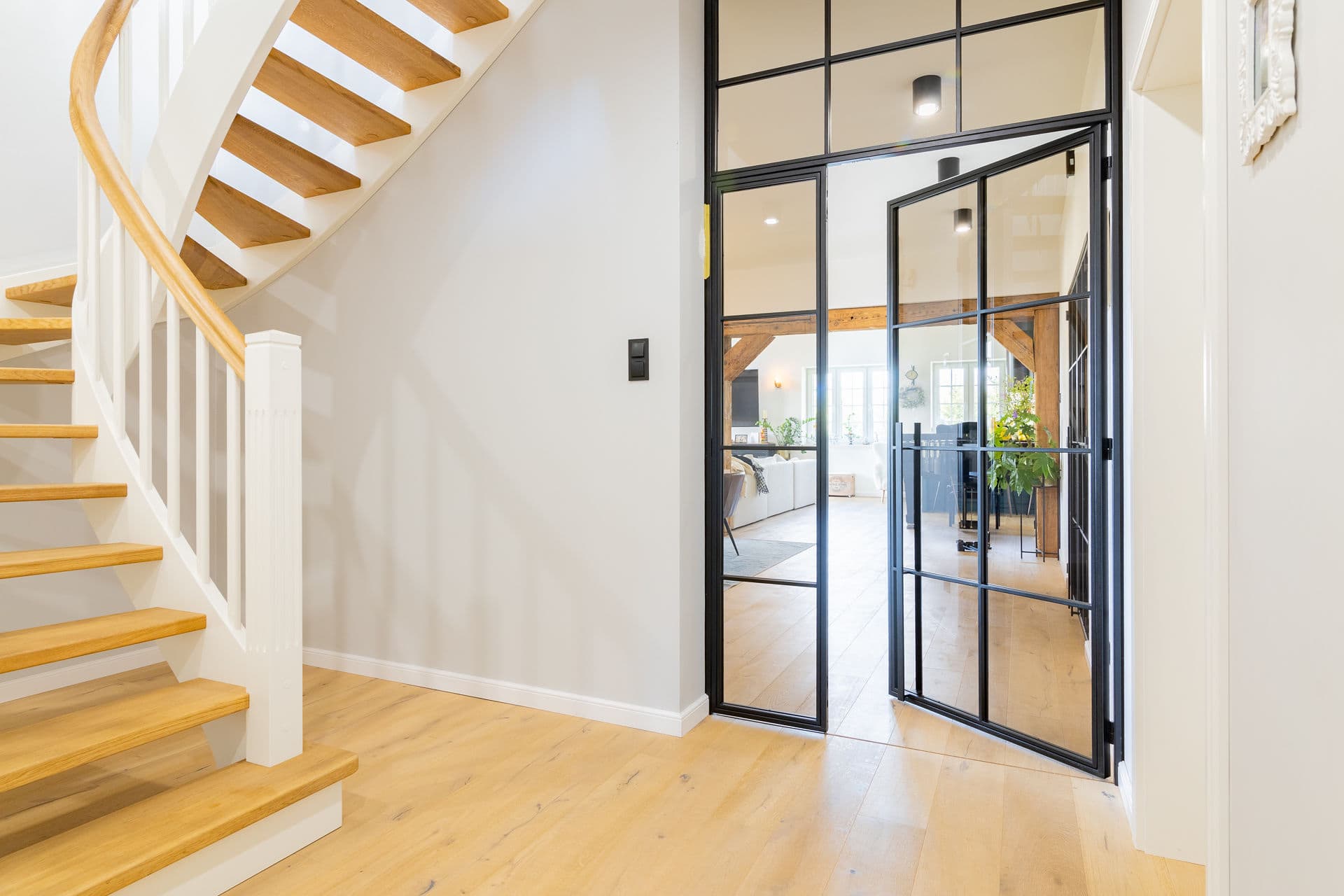 Drehtür mit Oberlicht neben der Holztreppe