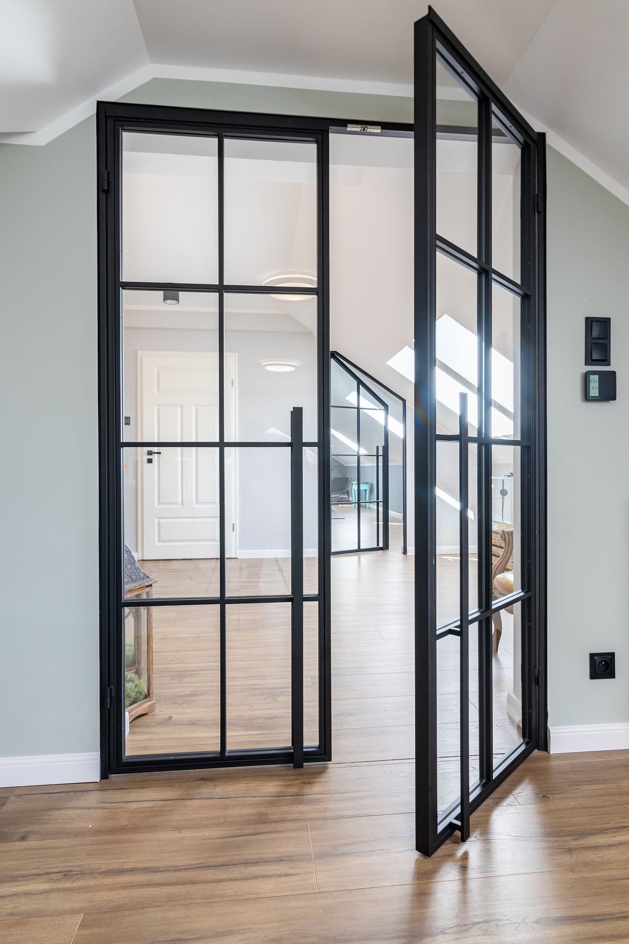 Doppeldrehtür im Obergeschoss mit salbeigrünen Wänden und Dachfenstern