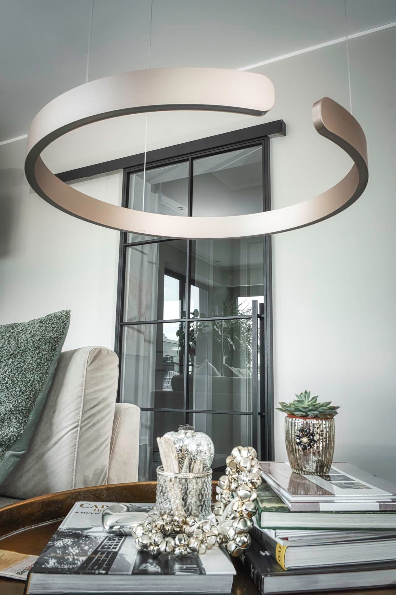 Geschlossene Doppelschiebetür aus Stahl und Glas mit Designerleuchte im Vordergrund