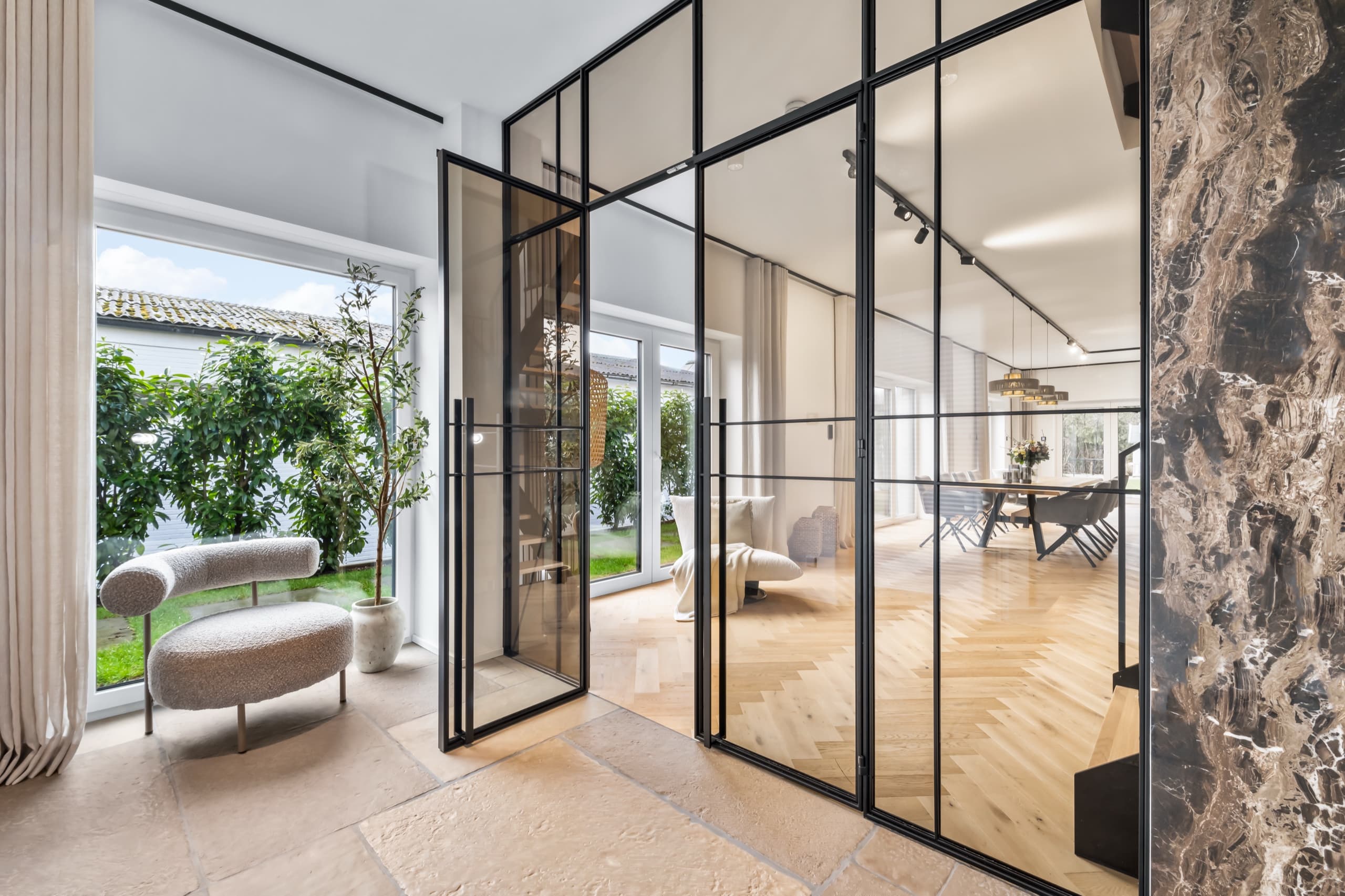 Blick vom Wohnzimmer durch die Doppeldrehtür in den Gartenbereich der Vorstadtvilla