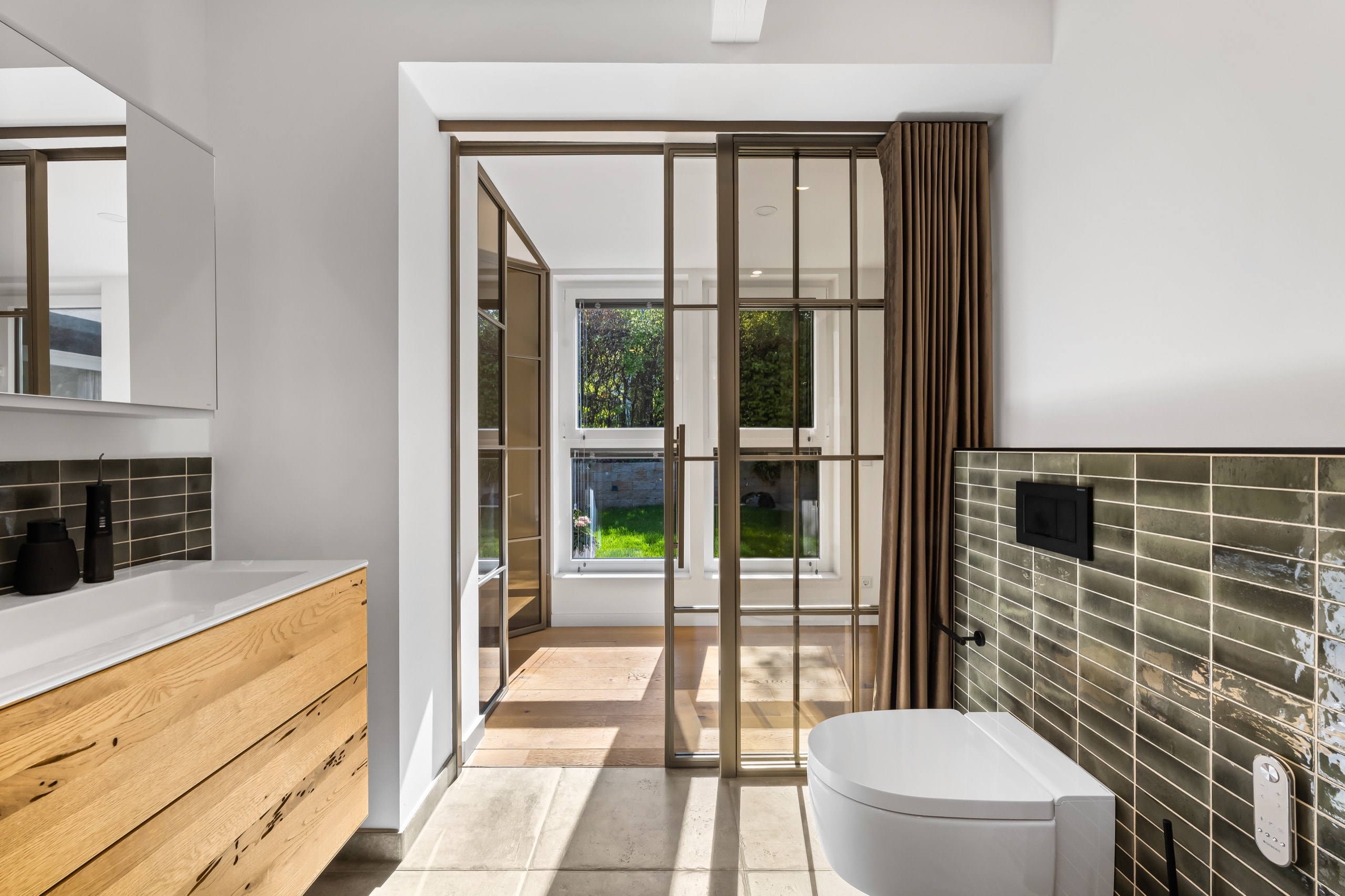 Schiebetür aus Stahl und Glas im Badezimmer mit Blick in den Garten