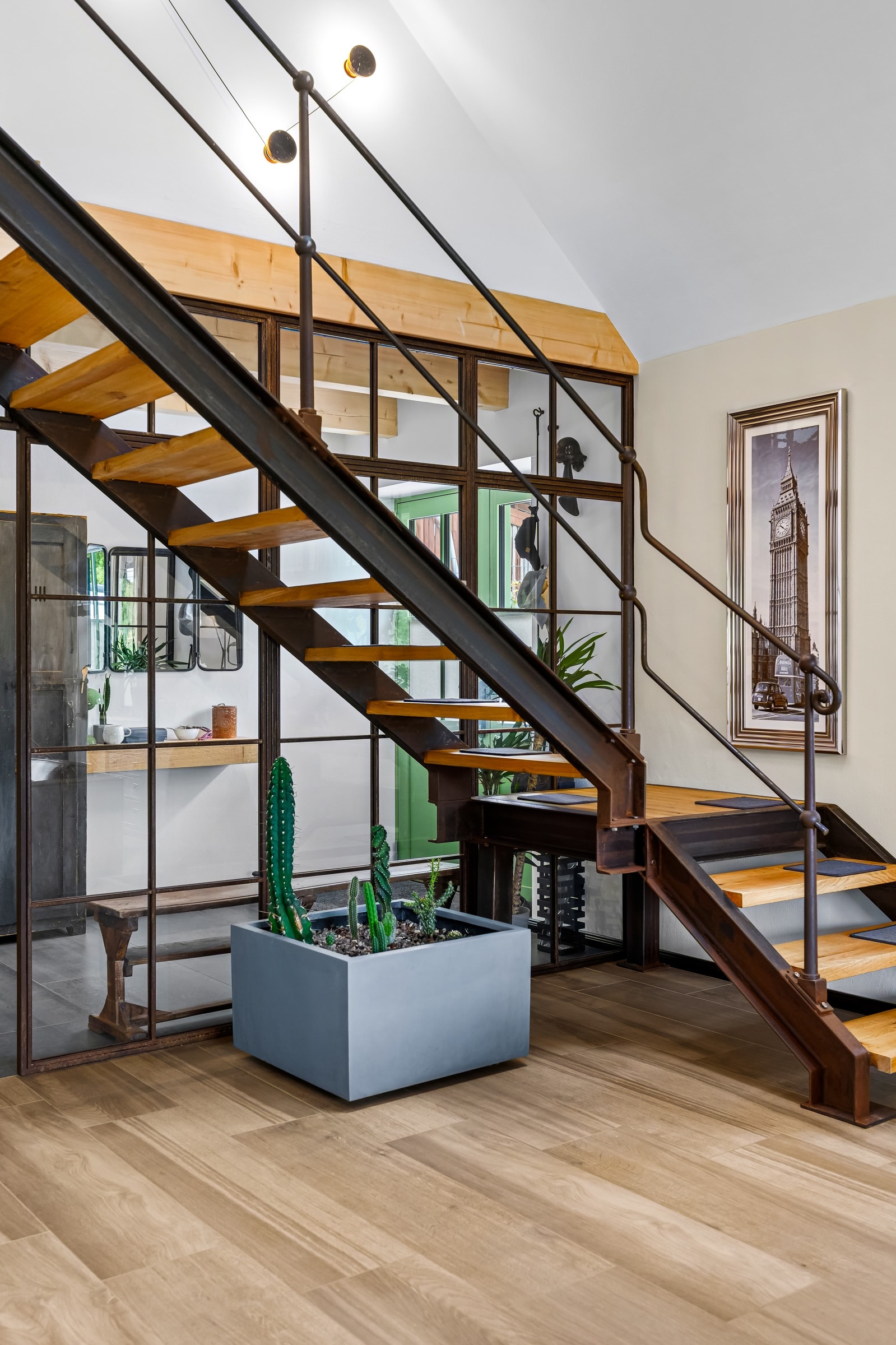 Frei stehende Stahltreppe mit Rohstahl-Wange, Holzstufen und Pflanzkübel
