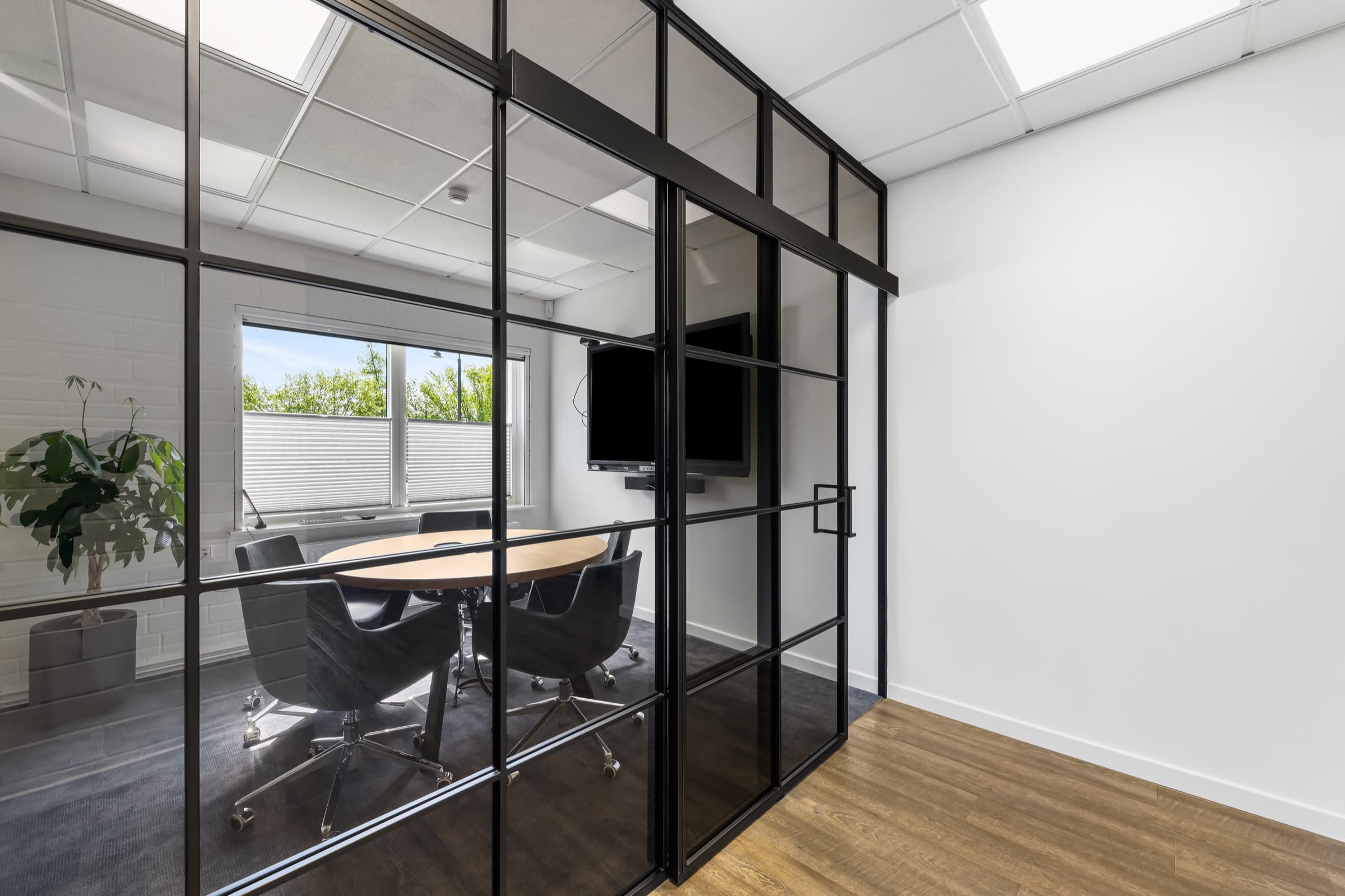 Besprechungs-Kubus aus Stahl und Glas mit rundem Holztisch, Bildschirm und Fenster
