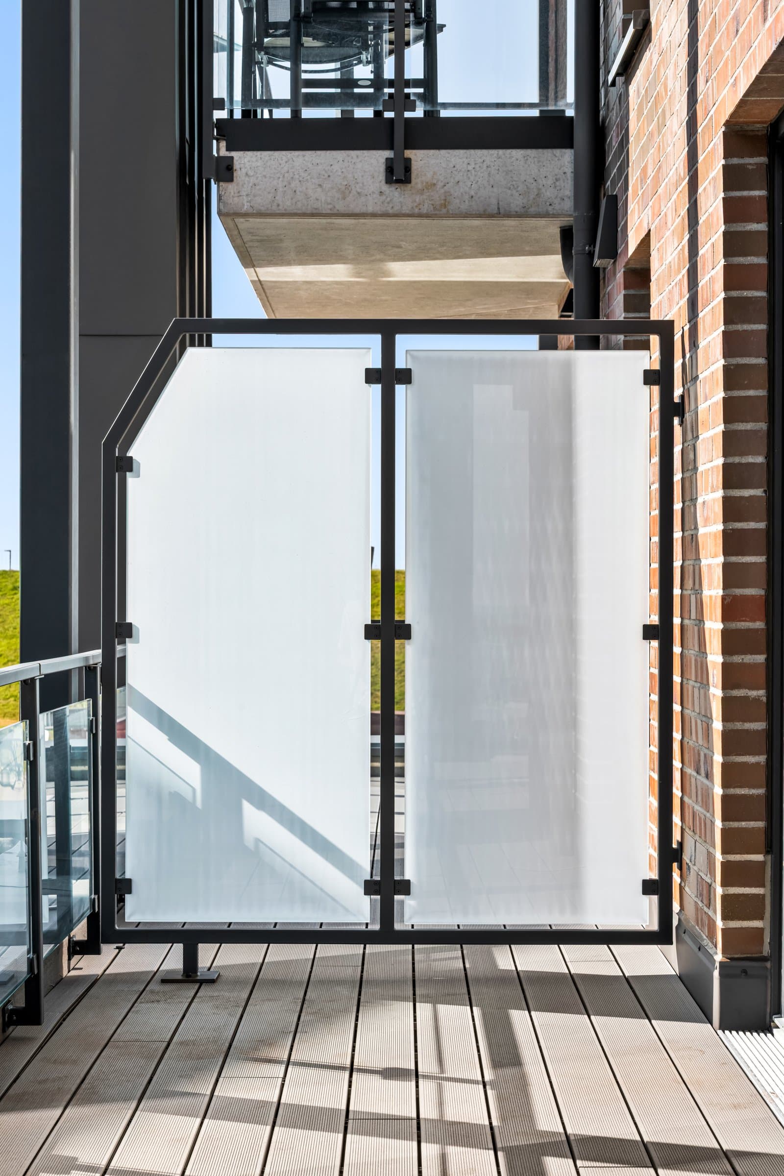 Balkon-Trennwand mit satiniertem Glas auf der Terrassendiele, Hochformat