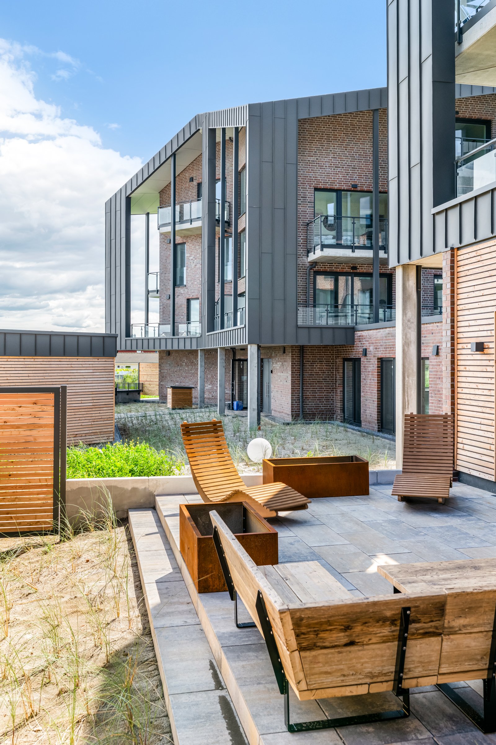Terrasse mit Loungemöbeln an der Südseite des Neubaus